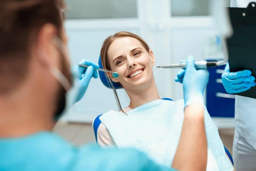 Dentista che prepara la paziente per il trattamento, mostrando cure dentali in Albania in una clinica moderna