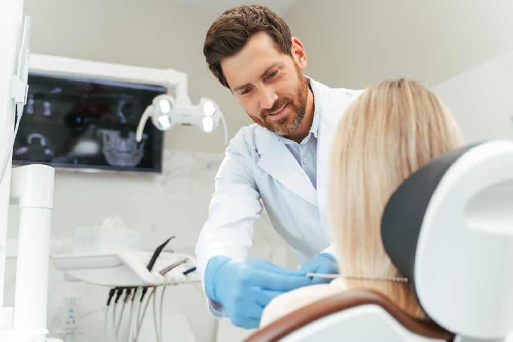 Dentista che consulta una paziente per un trattamento di implantologia dentale in Albania