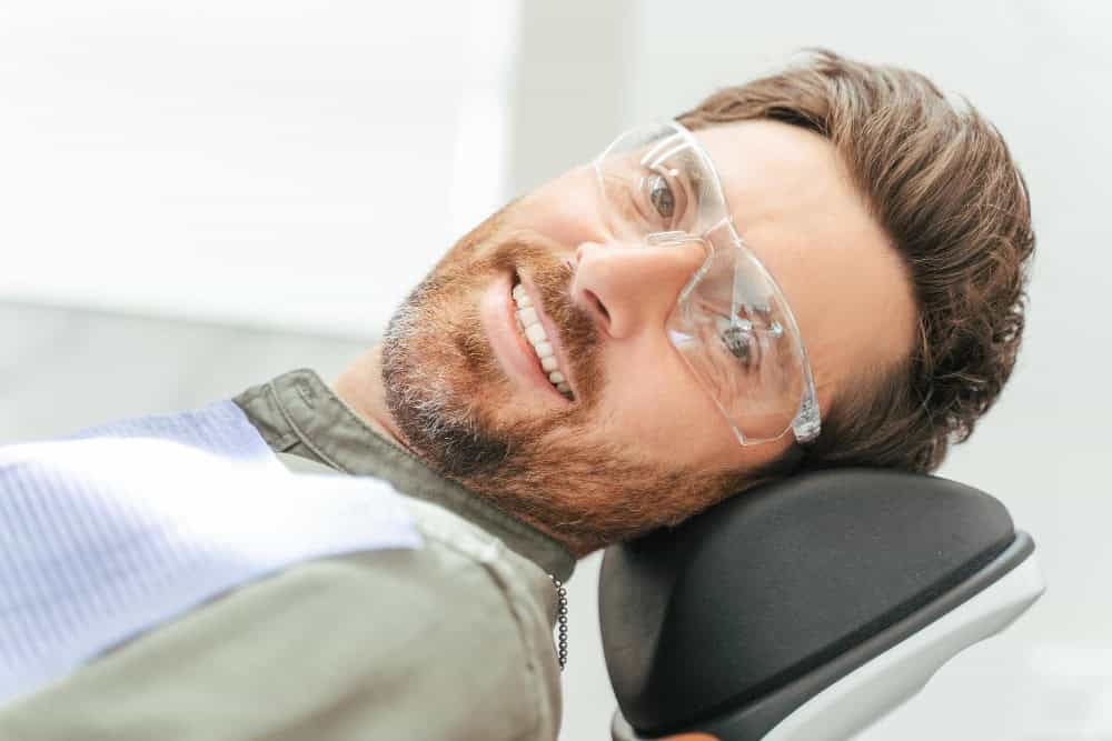 Paziente che controlla il risultato del sorriso dopo un trattamento di implantologia dentale in Albania