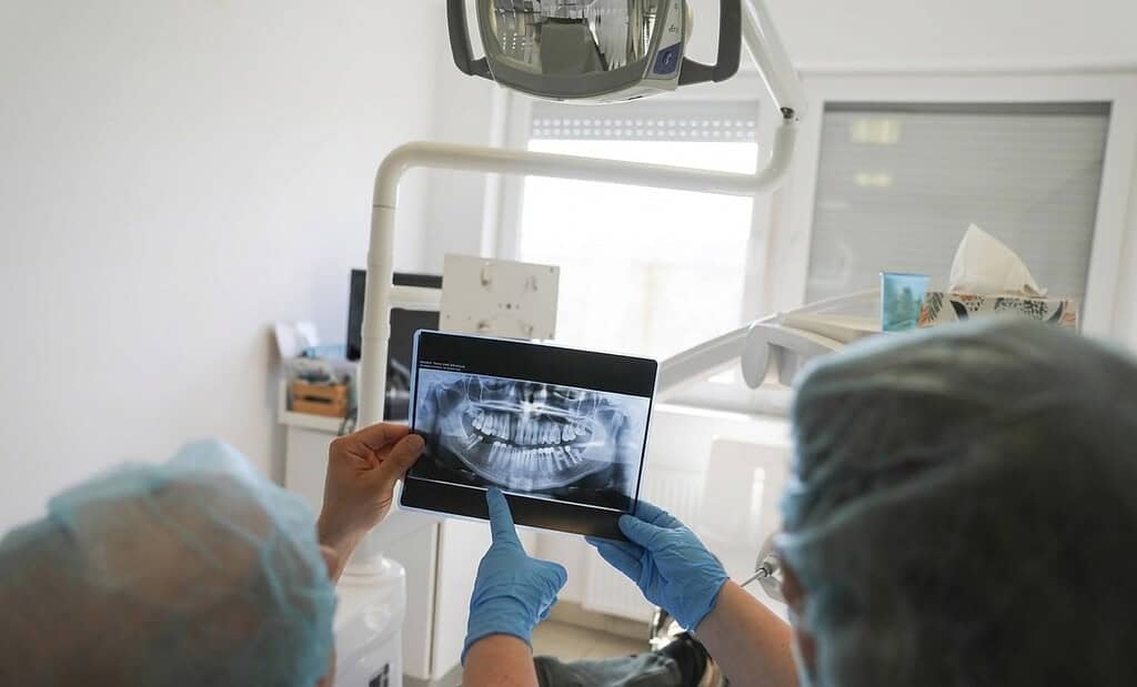 Specialisti che analizzano una radiografia panoramica prima di un trattamento con impianti dentali in Albania