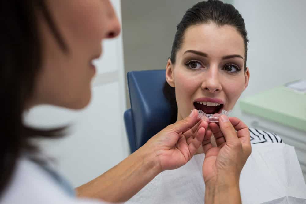 Dentists in Albania fitting clear orthodontic aligners for adult patients.