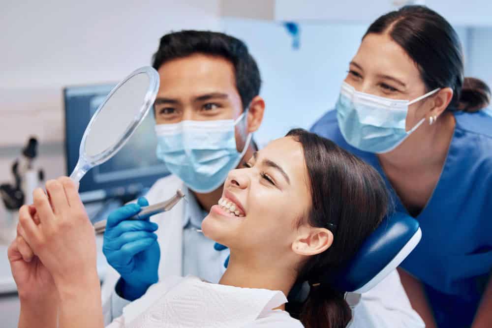 Dentists in Albania performing dental examination with patient smiling, dental clinic in Albania.