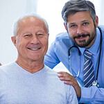 Friendly dentist with senior patient at Albanian dental clinic, offering dental treatments and check.