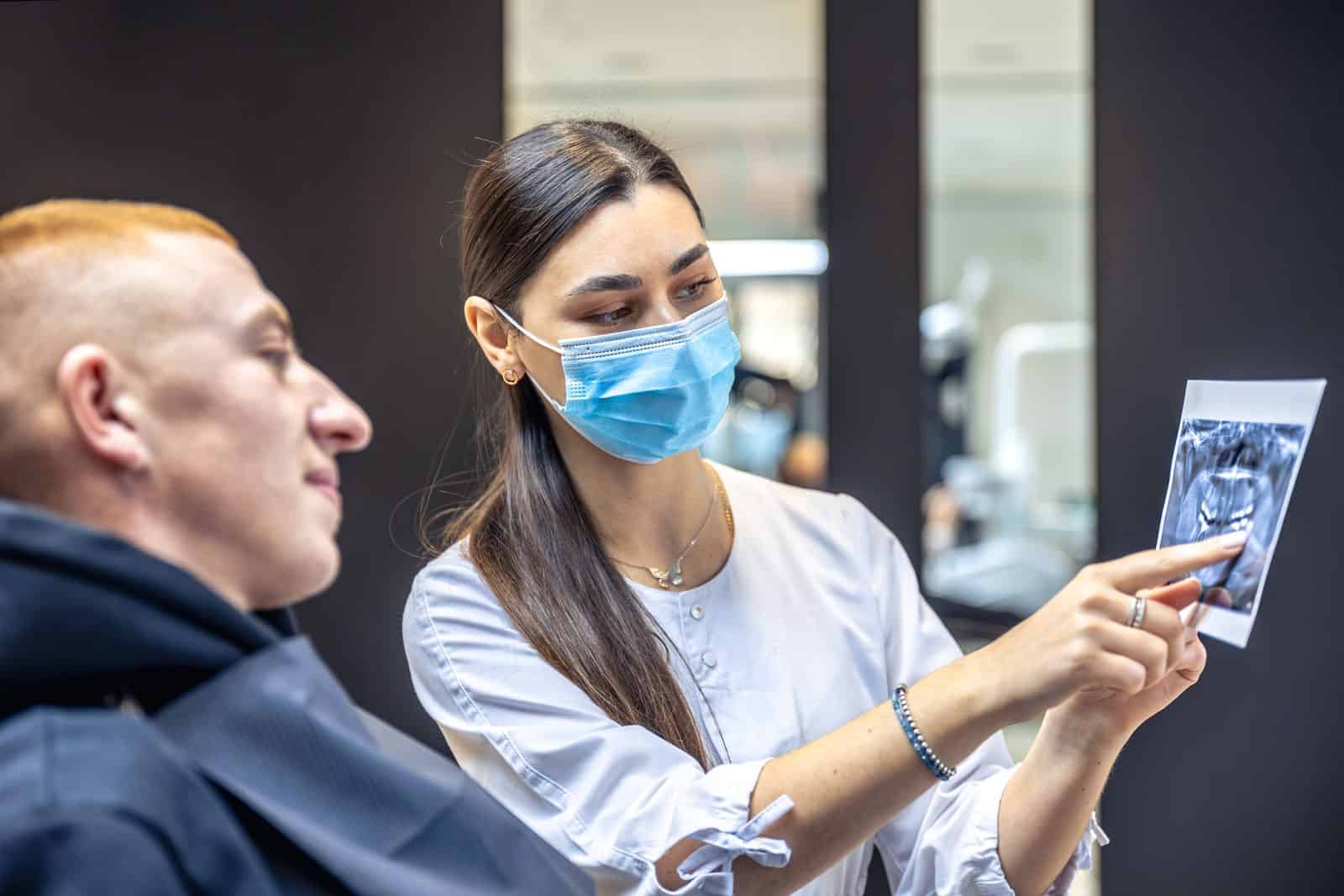 Dentists in Albania showing dental X-ray for treatment consultation.